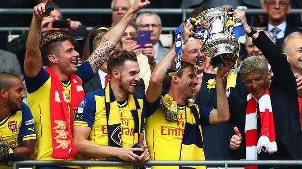 Arsene Wenger celebra amb els seus jugadors i el trofeu de la FA Cup després que l'Arsenal guanyés la competició dos anys seguits.