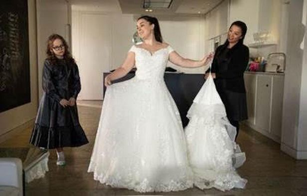 טרייסי בייקר מעוררת ספקולציות בחתונה כשהיא מנסה שמלת כלה מהממת