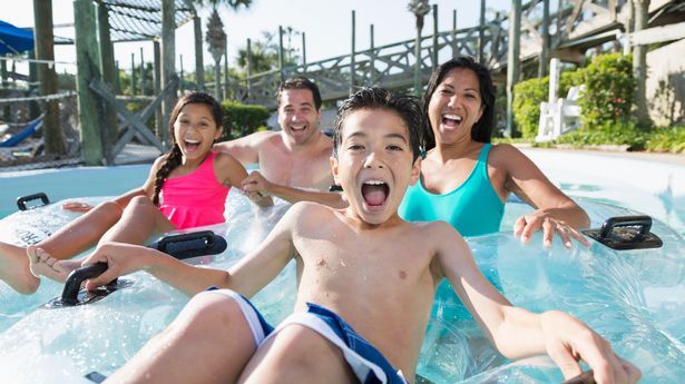 Família com dois filhos se divertindo no parque aquático